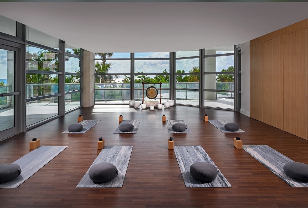 Yoga and meditation room with mats, bolsters and a gong by the glass