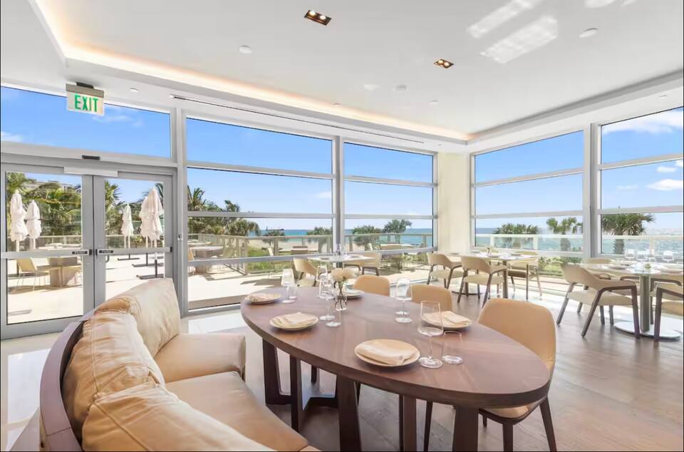 A dining area with a sofa and an ocean view