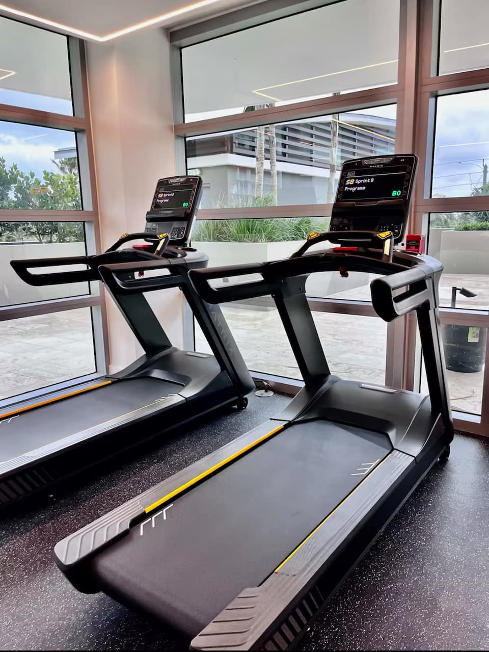 A treadmill in the resort fitness centre beside the glass