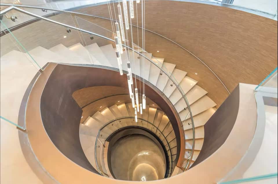 The resort's spiral staircase beneath a cascade of pendant lights
