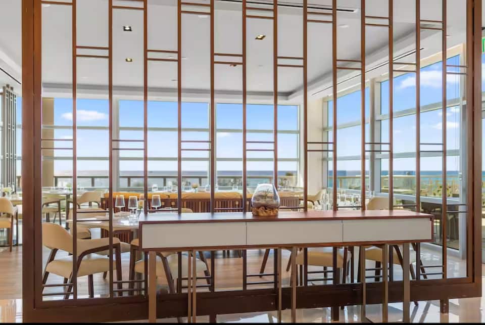 A dining room framed by a slatted wood screen