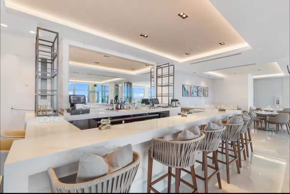 A restaurant bar with island seating and ocean views
