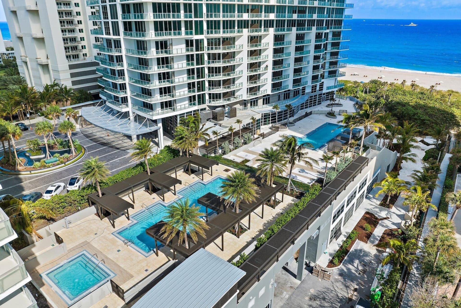 Aerial view of the resort's pool terraces and palms above the beach