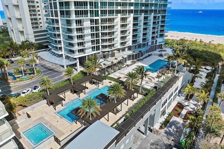Aerial view of the resort's pool terraces and palms above the beach