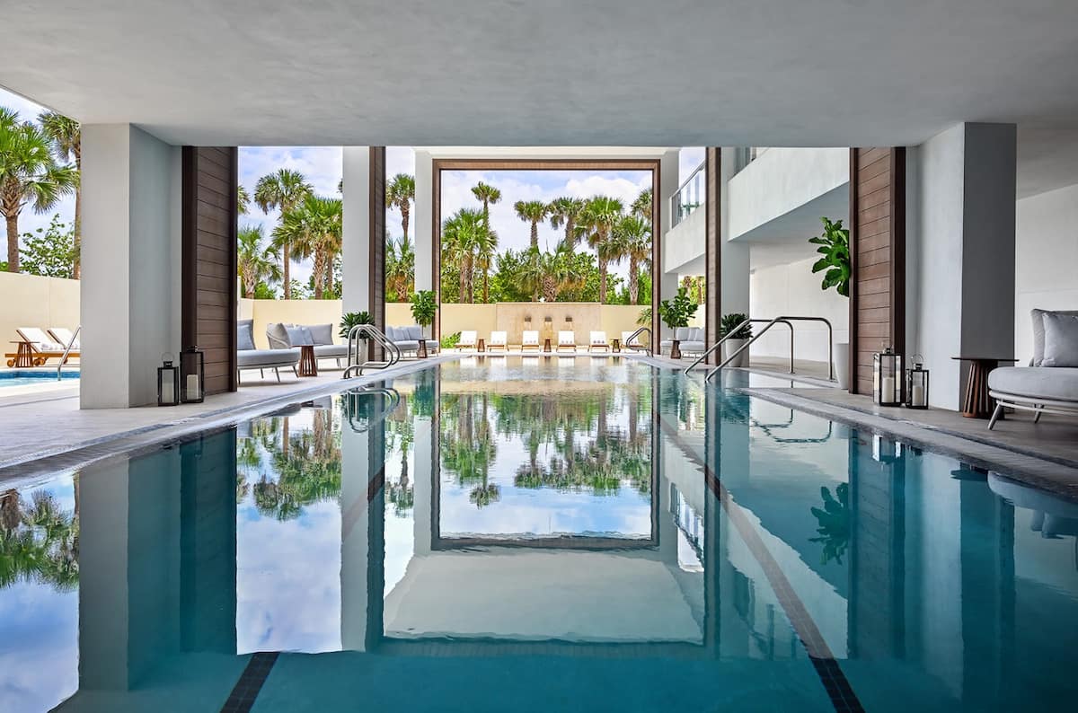 Serene indoor hydrotherapy pool with palm reflections in the glass