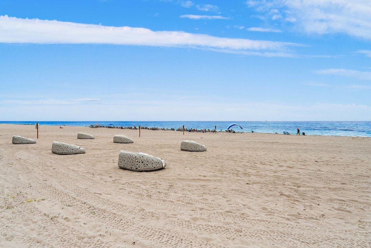 A wide stretch of Singer Island beach with loungers and umbrellas