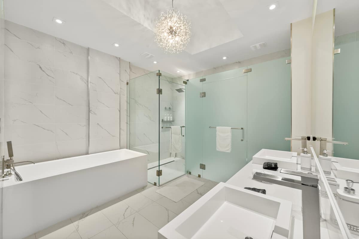 The primary bathroom with a freestanding soaking tub, glass shower and double vanity