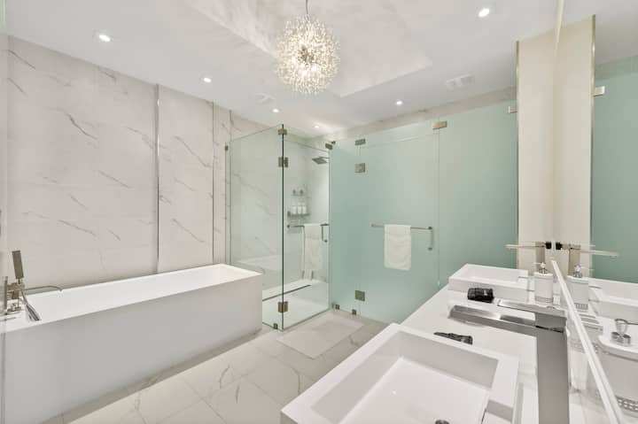 The primary bathroom with a freestanding soaking tub, glass shower and double vanity