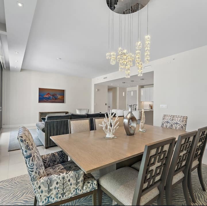 The dining table beneath a cascading crystal pendant chandelier