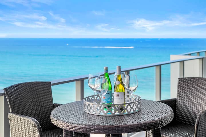 A balcony table set with glasses, the Atlantic filling the view behind