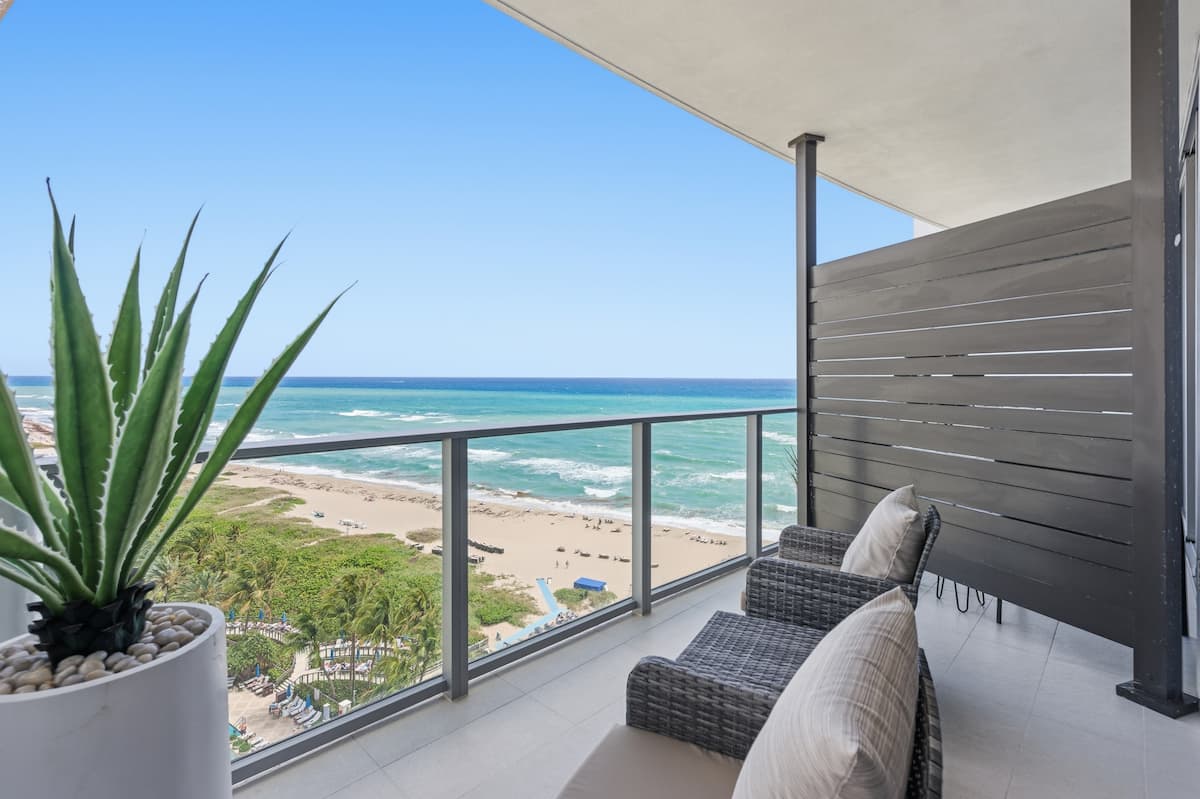 A balcony with an aloe planter overlooking the beach