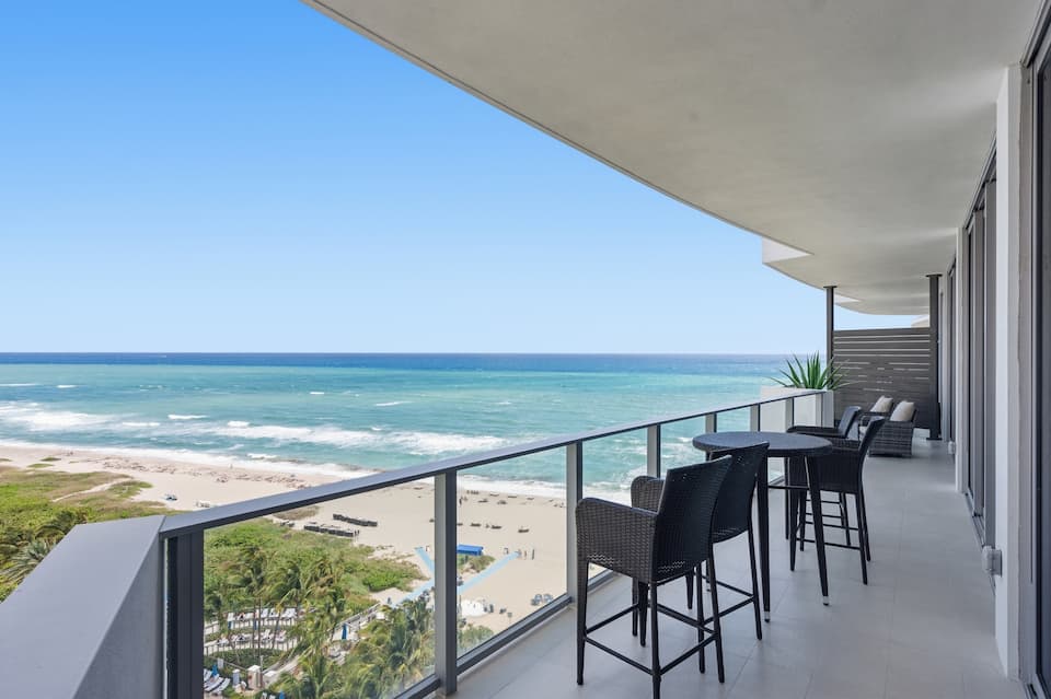 Balcony bar seating with an aerial view of the pools and beach