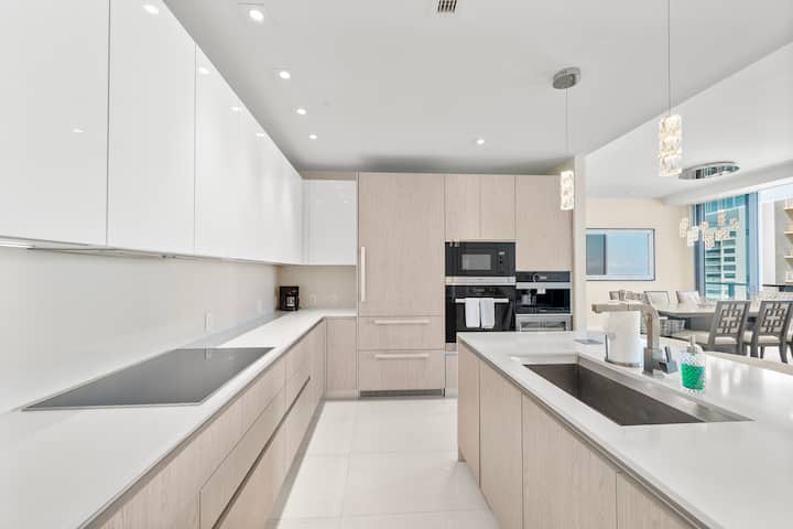 The long white kitchen counter with the induction cooktop, the dining room beyond