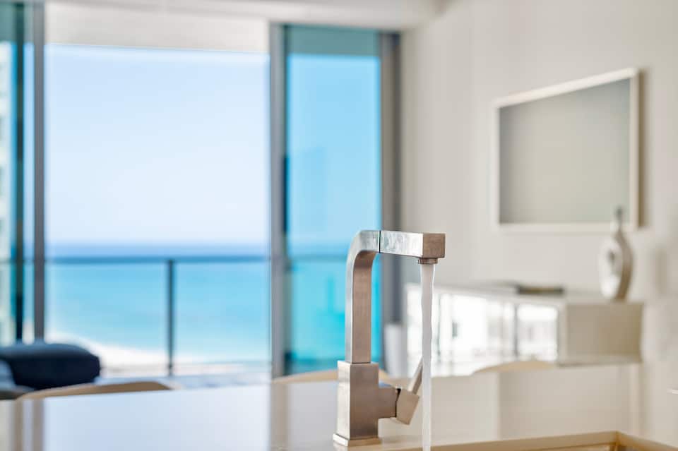 The ocean seen through the balcony glass beside the kitchen