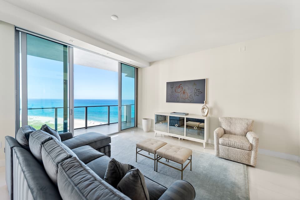 The living room with a deep sofa facing the ocean windows