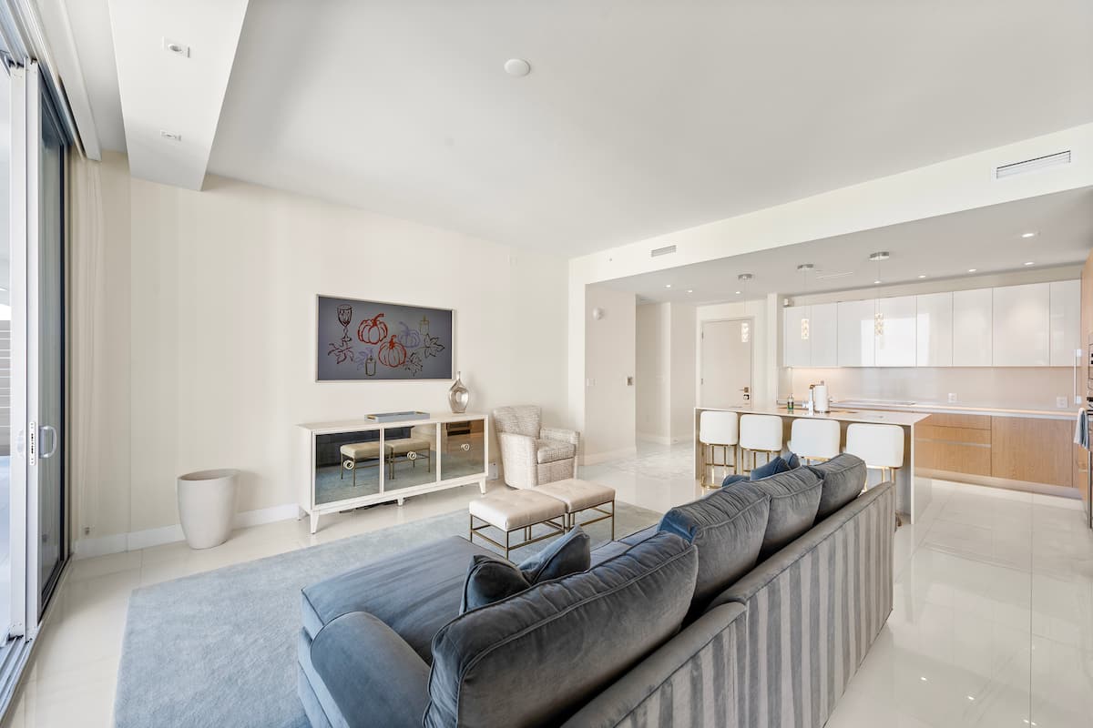 The living room from the entry, with the sofa, the television wall and the balcony beyond